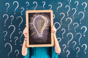 Woman Showing Light Bulb on Blackboard